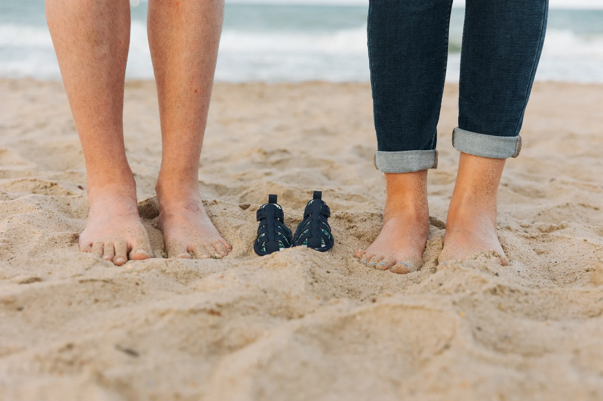 Pies de padres en la playa a la espera de que llegue el pequeño